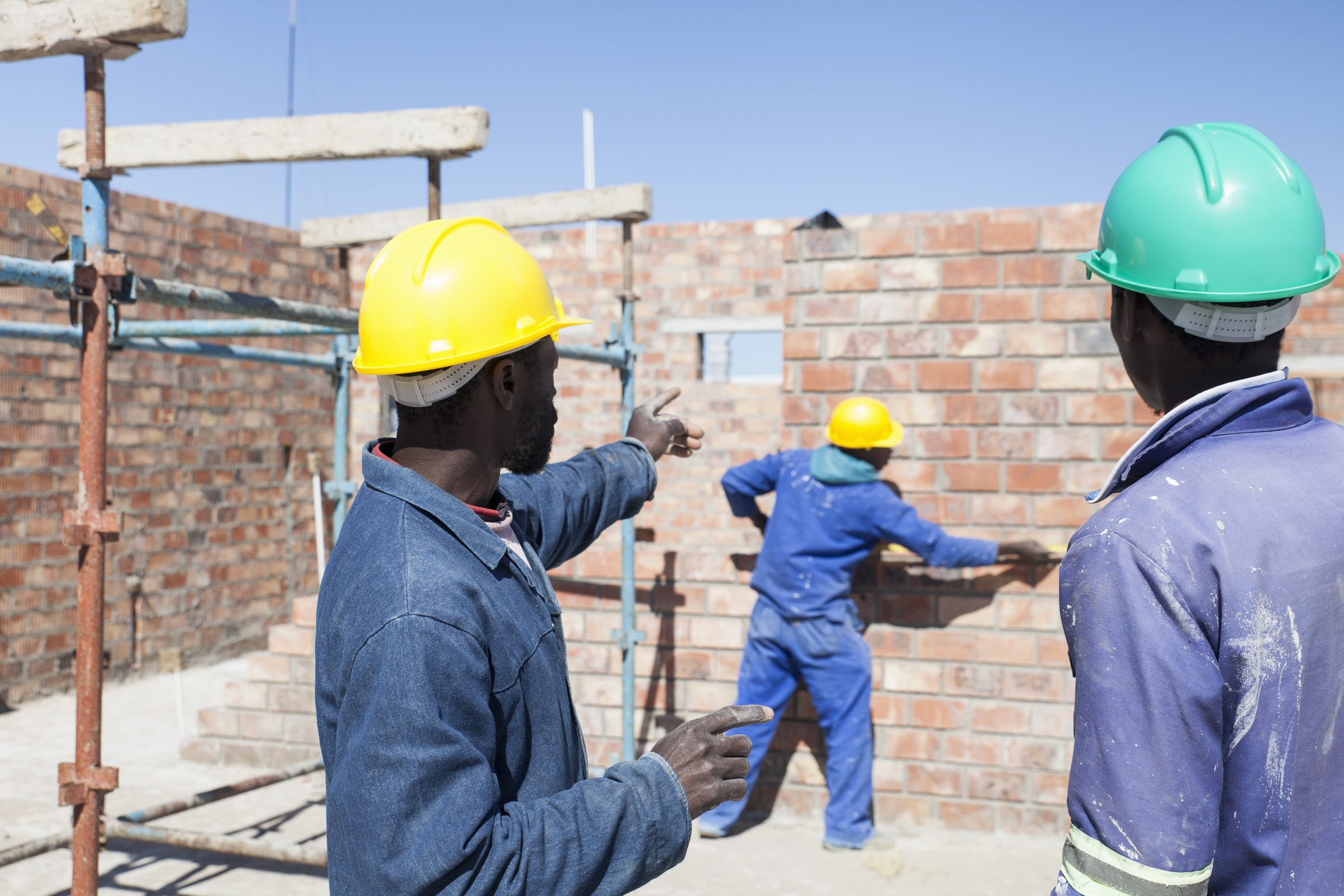 Masons raising blockwork walls on a residential site