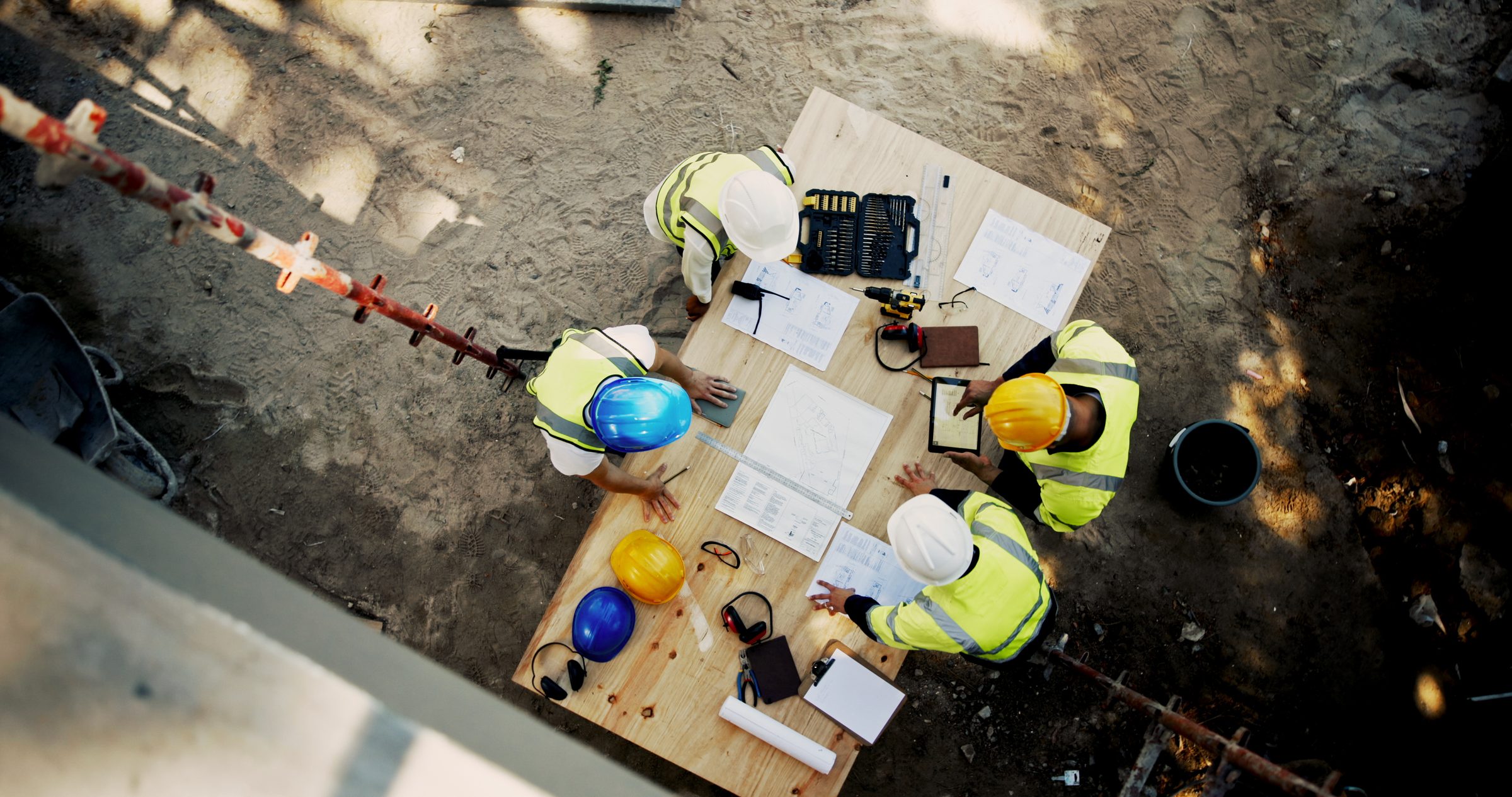 Project team reviewing drawings around a site table