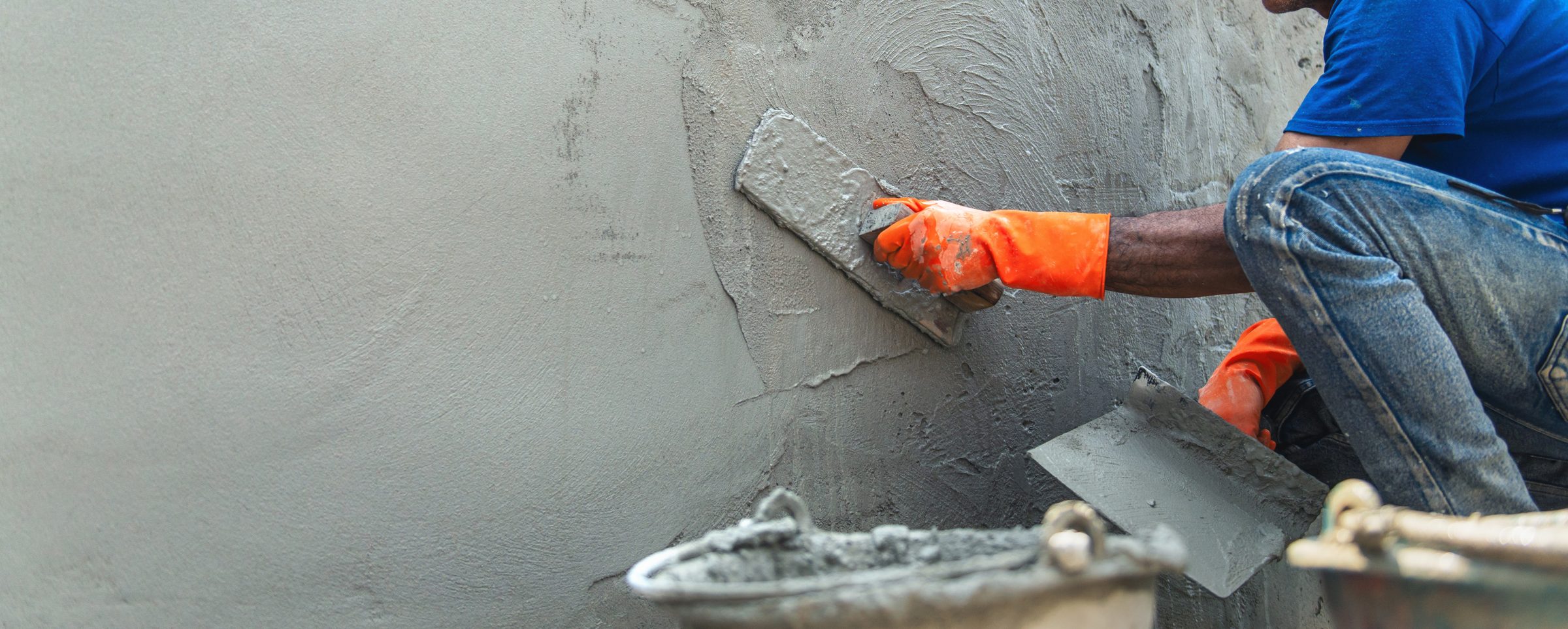 Worker floating a smooth plaster finish onto a wall